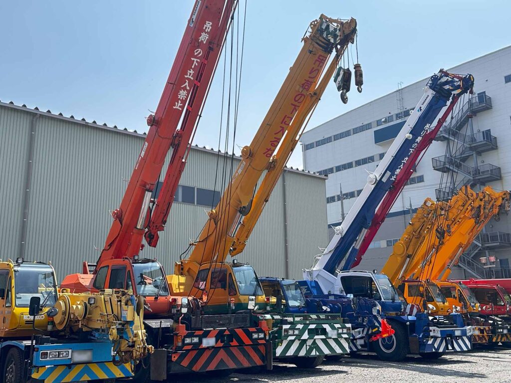 三興機械株式会社、神戸営業所前に並ぶクレーン車の写真